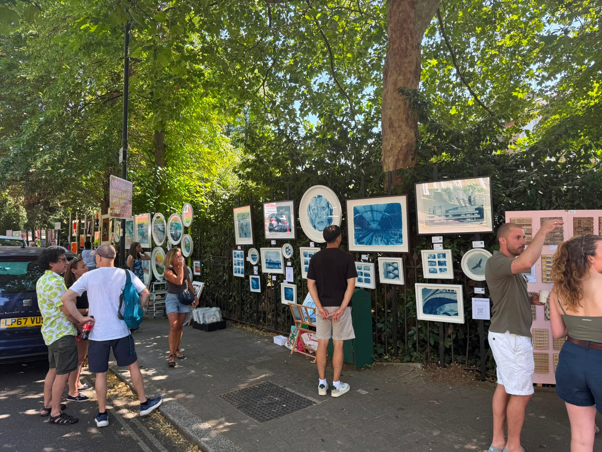 Visitors pausing to look at framed artwork at Brixton Urban Art Fair